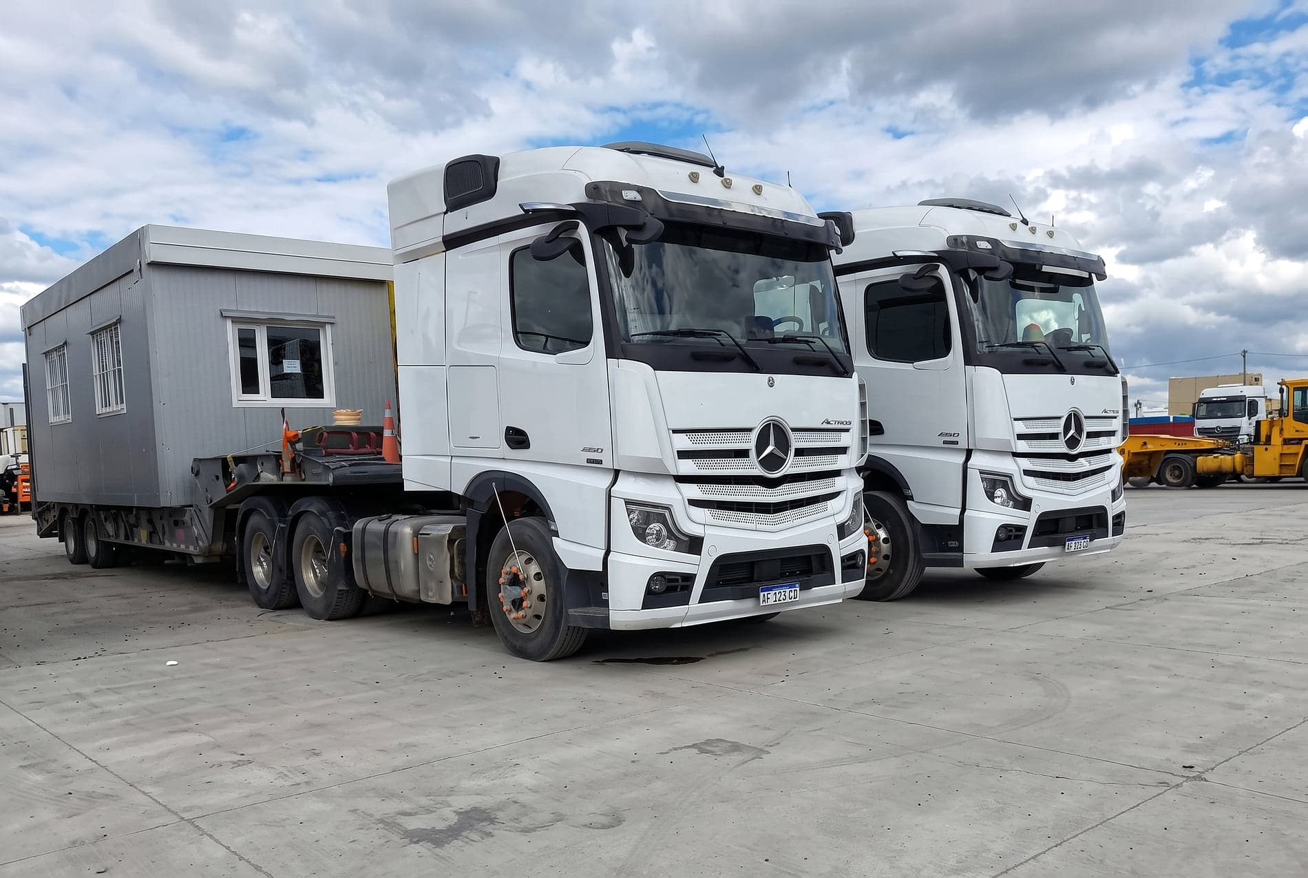 Dos tractores Mercedes-Benz Actros en playa de maniobras, uno con un módulo cargado sobre carretón