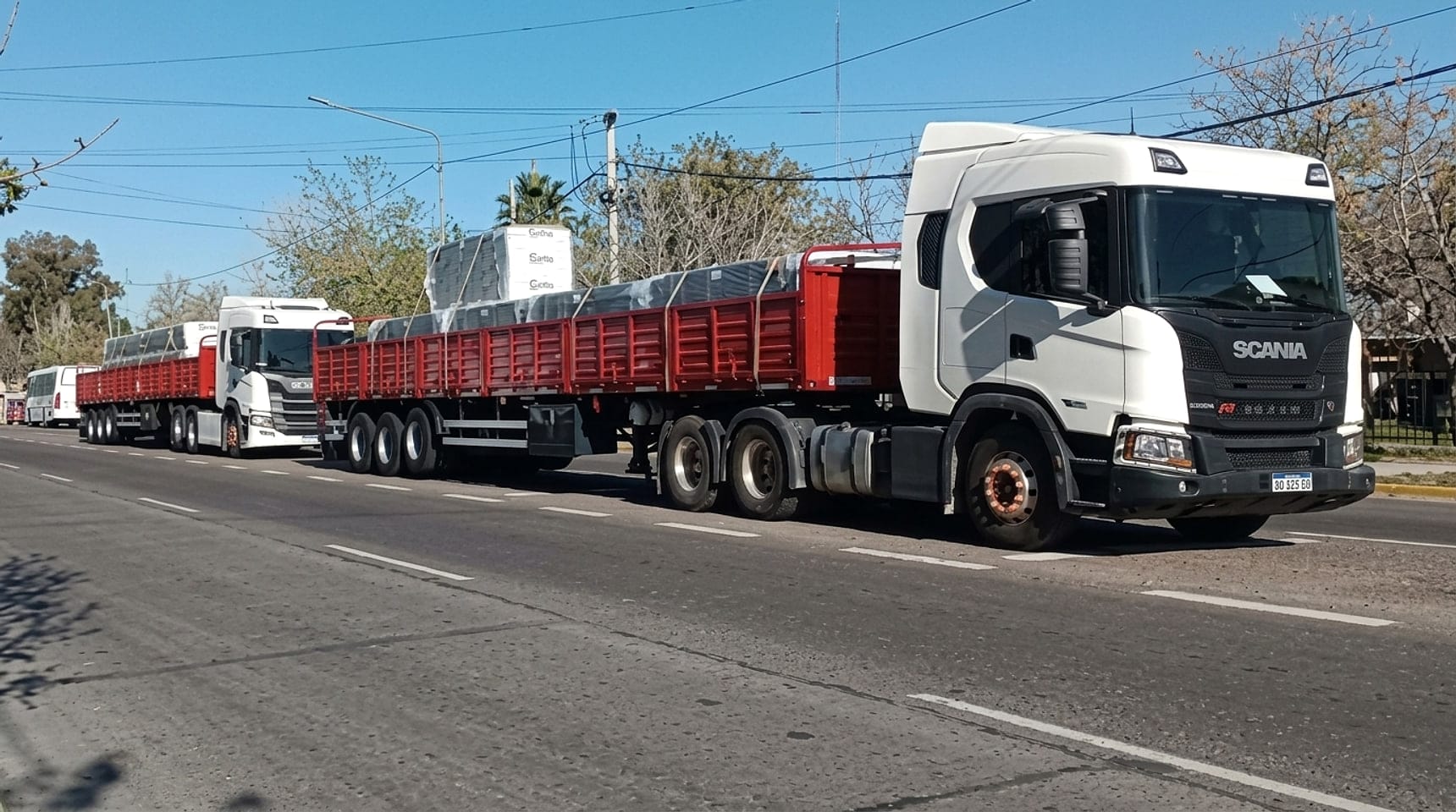 Tractores Scania con semirremolques cargados circulando en formación